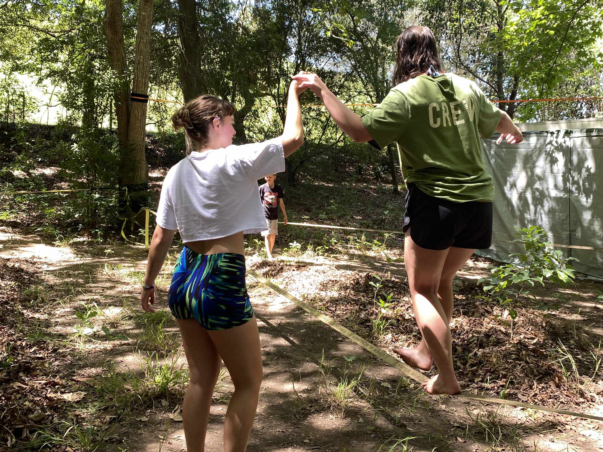 Emma assisting a beginner slackliner